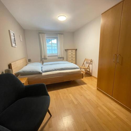 a bedroom with a bed and a chair and a window at Chalet Milanovic in Dalaas
