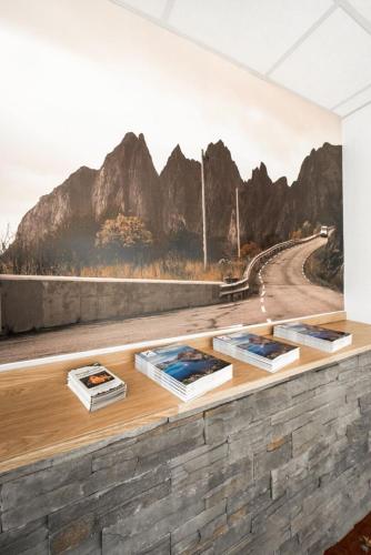 a mural of a mountain road on a wall at Senja Hotell in Finnsnes