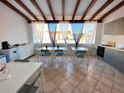 a kitchen with two tables and chairs in a room at Mamamia #Lipari in Lipari