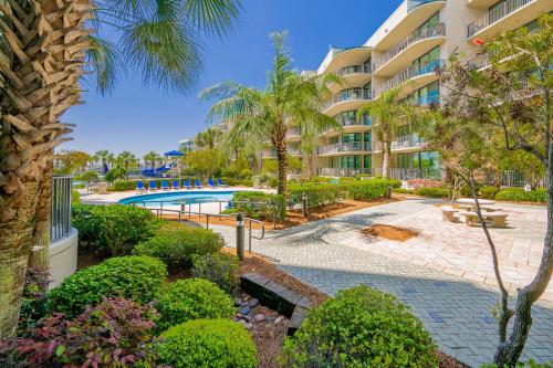 an apartment complex with a swimming pool and palm trees at Phoenix on the Bay 1122 condo in Orange Beach