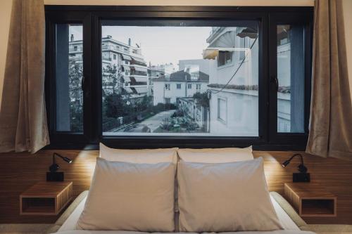 a bed in a room with a large window at Frourio Lodge B2 in Larisa