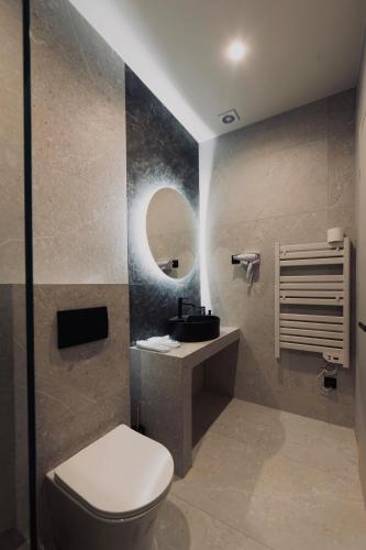 a bathroom with a toilet and a sink and a mirror at Frourio Lodge B2 in Larisa