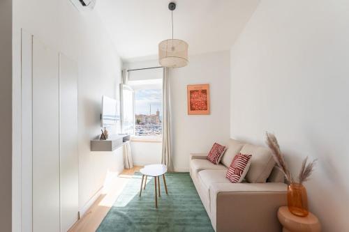 a white living room with a couch and a table at Petit Levant in La Ciotat