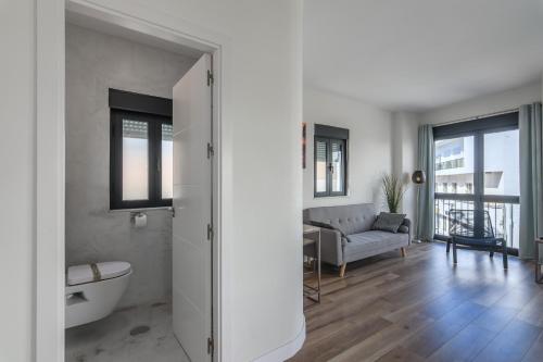 a bathroom with a tub and a couch in a room at River Corner - Centro Ayamonte in Ayamonte