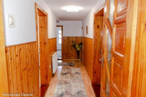 a hallway with wood paneled walls and a door at Vila Daiana- Acceptam vouchere vacanta in Moieciu de Jos