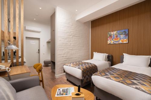 a hotel room with two beds and a couch at IGMAR Villas & Aparts Hotel in Tashkent