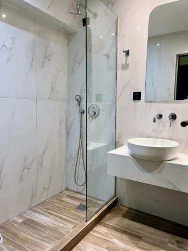a bathroom with a glass shower and a sink at Rotonda Hotel in Thessaloniki