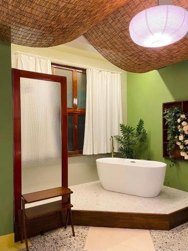 a bathroom with a large bath tub and a plant at 光陰GUANGinn in Hsinchu City