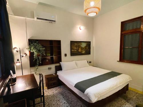 a bedroom with a bed and a desk and a desk at 光陰GUANGinn in Hsinchu City