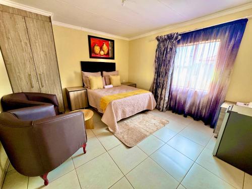 a bedroom with a bed and a chair and a window at BotseBontle Lodge in Lenting