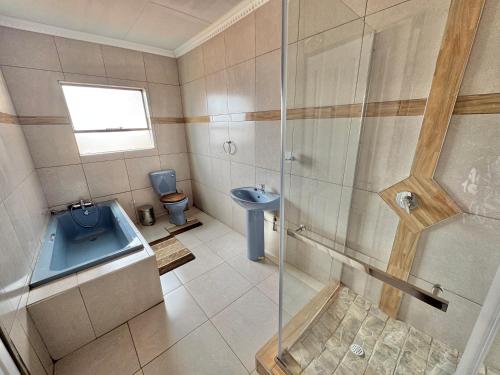 a bathroom with a shower and a toilet and a sink at BotseBontle Lodge in Lenting