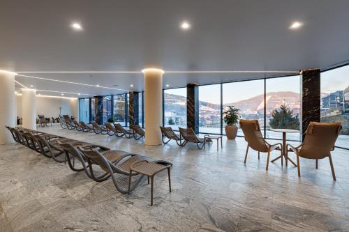 a large room with chairs and tables and windows at Hotel Podgorie Spa in Bukovel