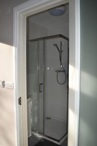 a glass shower stall in a bathroom with a mirror at Alensgrove Maisonette C in Leixlip