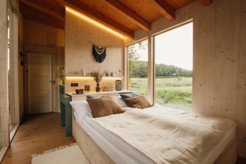 a large bed in a room with a large window at Útulna Rychleby in Vápenná