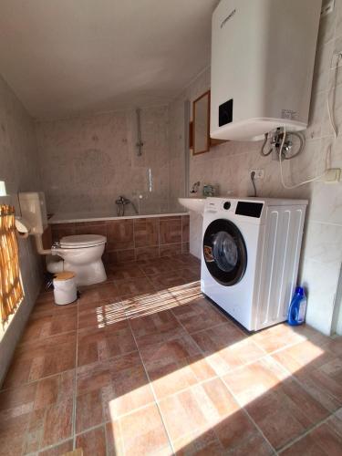een badkamer met wasmachine en toilet bij De lütt Stuuv in Barth
