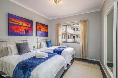 a bedroom with two beds and a window at Flip-Flop Flat in Langebaan