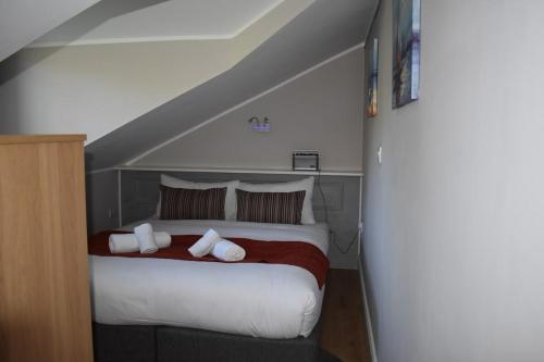 a bedroom with a bed with white sheets and pillows at Alensgrove Maisonette D in Leixlip