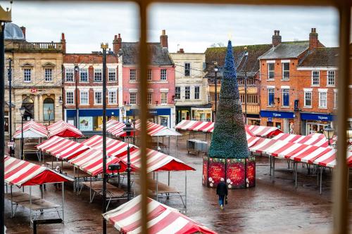 a man walking past a christmas tree in a city at The Links Apartments in Newark-on-Trent