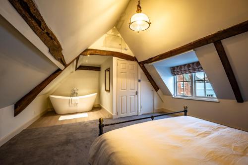 a attic bedroom with a bed and a bath tub at The Links Apartments in Newark-on-Trent