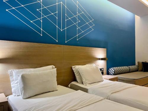 a bedroom with two beds and a blue wall at Rotonda Hotel in Thessaloniki
