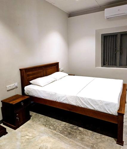 a bedroom with a bed and a window at Gate House Mirissa in Mirissa