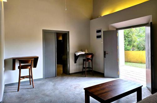a living room with a wooden table and a table sidx sidx sidx at Gate House Mirissa in Mirissa