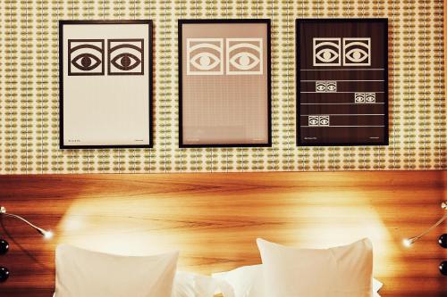 ein Schlafzimmer mit zwei gerahmten Bildern an einer Wand in der Unterkunft NOFO Hotel, WorldHotels Crafted in Stockholm