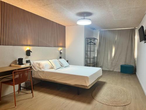 a bedroom with a bed and a desk and a table and chair at Abacoa Life in Alicante