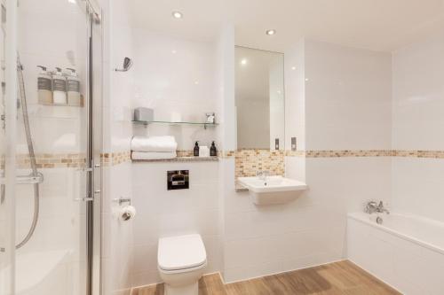 a white bathroom with a toilet and a sink at Carnoustie Golf Hotel 'A Bespoke Hotel’ in Carnoustie