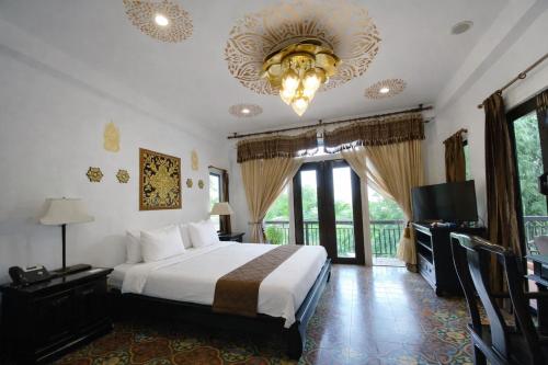 a hotel room with a bed and a chandelier at Pludhaya Resort & Spa in Phra Nakhon Si Ayutthaya