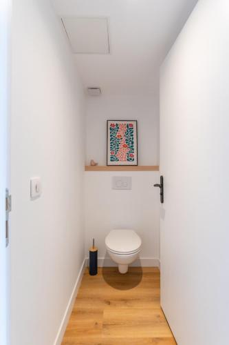 a bathroom with a toilet in a white room at Petit Emba in La Ciotat