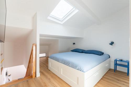 a bedroom with a white bed and a skylight at Petit Emba in La Ciotat