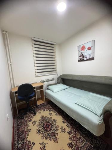 a bedroom with a bed and a desk and a chair at SS Stan in Pale