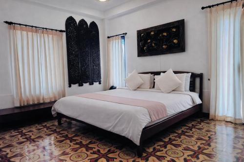 a bedroom with a large bed with white sheets at Pludhaya Resort & Spa in Phra Nakhon Si Ayutthaya