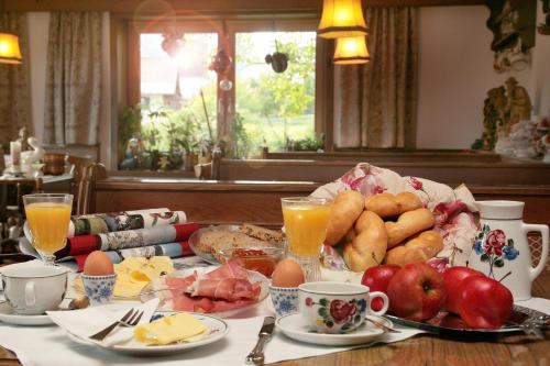 a breakfast table with eggs potatoes and fruit on it at Pension Lacknerhof in Piesendorf