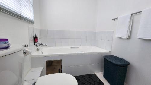 a white bathroom with a sink and a toilet at 14 Madison Palms East in Johannesburg