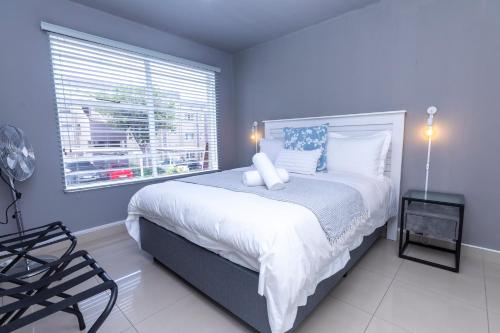 a bedroom with a large bed and a window at 14 Madison Palms East in Johannesburg