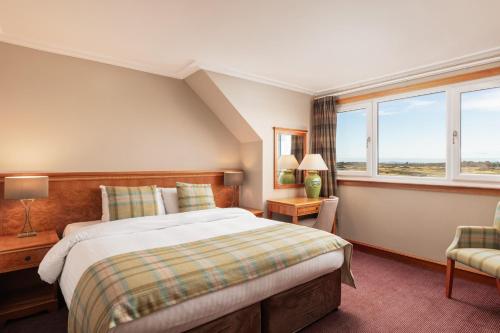a bedroom with a large bed and a window at Carnoustie Golf Hotel 'A Bespoke Hotel’ in Carnoustie