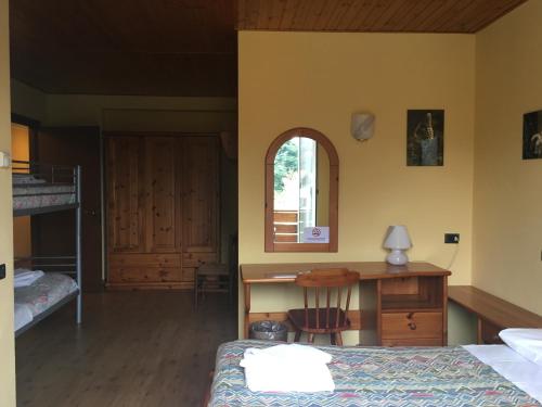 a bedroom with a bed and a desk and a bunk bed at Sporting Club in Ballabio
