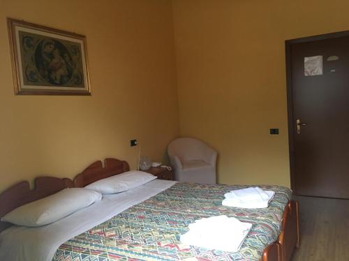 a bedroom with a bed with two pillows and a chair at Sporting Club in Ballabio