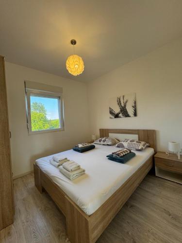 a bedroom with a large bed with towels on it at Vila Amante in Gornja Toplica