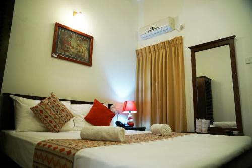 a hotel room with a bed with a mirror and a mirror at Kandy Moon Hills Hotel in Kandy