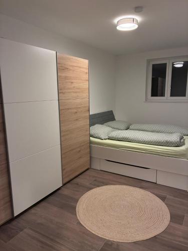 a small bedroom with a bed and a rug at Hügelland Apartment in Elxenbach