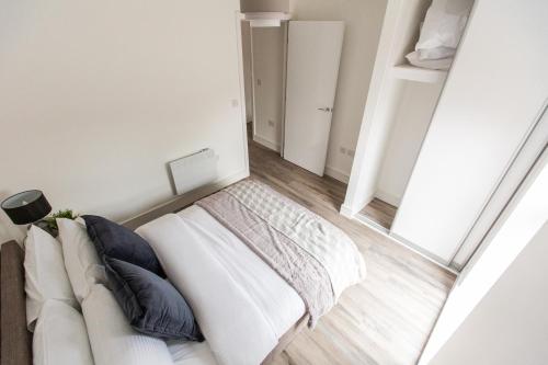 a white bed in a room with a couch at The Interchange - 2-Bed - Brand New - Central in Manchester
