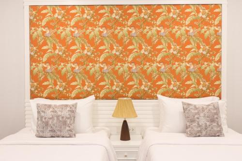 a bedroom with two beds and an orange wallpaper at Alisea Pool Villa Aonang in Ao Nang Beach