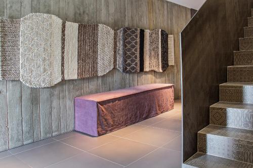 a room with a bench and a wall with carpets at Senses Violett Suites - Adults Only in Zell am See