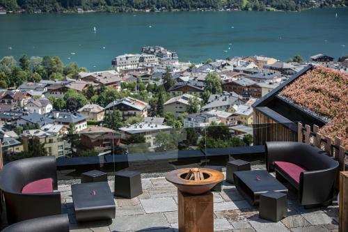 a balcony with chairs and a view of a city at Senses Violett Suites - Adults Only in Zell am See