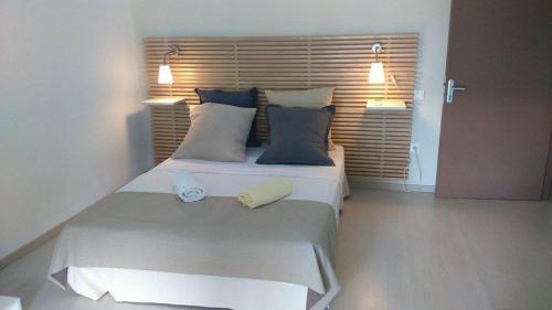 a bedroom with a large white bed with two pillows at Leu Pied Dans L'Eau in Saint-Leu