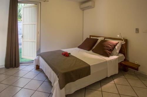 ein Schlafzimmer mit einem Bett mit einer roten Blume darauf in der Unterkunft Leu Pied Dans L'Eau in Saint-Leu