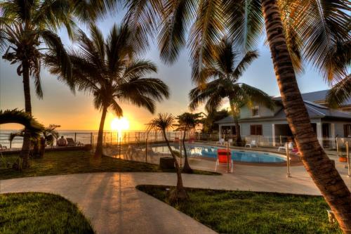 a house with a swimming pool with palm trees at Leu Pied Dans L'Eau in Saint-Leu
